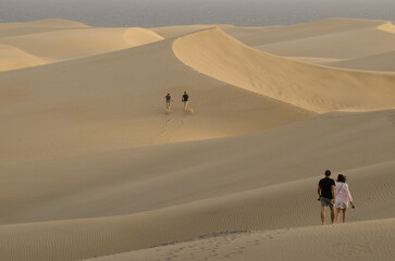 People walking in the Maspalomas Dunes. Natural Reserve of the Maspalomas Dunes. San Bartolome de Tirajana. Gran Canaria. Canary Islands. Spain.