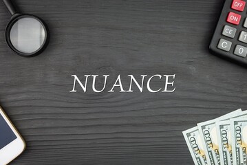 NUANCE - word (text) and money dollars on the table, phone magnifying glass (loupe) and calculator....