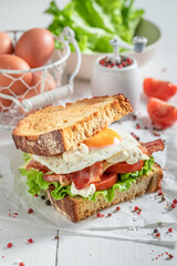 Fresh and healthy toasted sandwich with bacon, mayonnaise and egg.