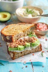 Healthy and fresh sandwich with avocado, salmon and dill.