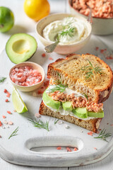 Crunchy and homemade sandwich with avocado, salmon and dill.