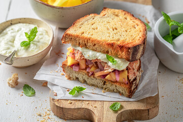 Delicious and sweet sandwich with chicken, fruits, herbs and onion.