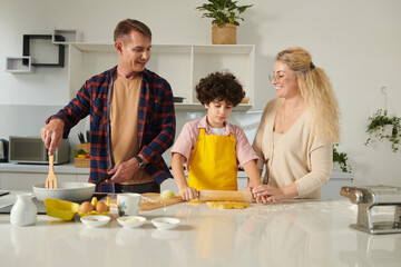 Joyful family cooking pasta at home for the first time