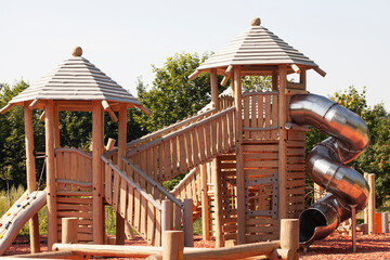 Modern children's playground for outdoor games, a slide pipe made of metal, pyramids made of wood