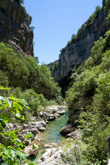 an emerald coloured river winds through a rocky gorge, the Anisclo Canyon, Ordesa National Park, Aragon Spain, blue sky