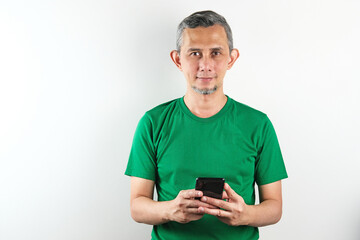 Portrait of Asian Man with mobile phone in hands, typing message, using social media.
