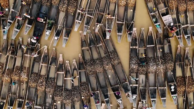 Aerial view of Jadukata River in Sylhet, Bangladesh. Locals are collection stone and sand from riverbed. Thousands of boats are lined up in the shore.