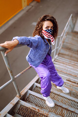 Funky young woman with american bandana dancing alone in the street. Sport, dancing and urban culture concept. US patriot.
