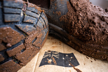 Muddy boots on a farm in Australia. Dirty shoes covered in dirt and foot and mouth disease. Bio security to stop contaminated footwear and clothes spreading disease in cows