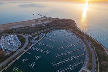 Aerial view of green parks and harbors on peninsulas of Montrose, Chicago at sunrise