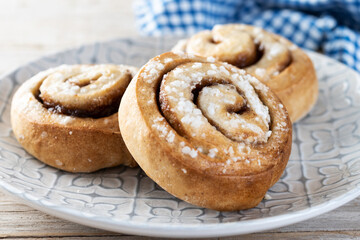 Cinnamon rolls buns. Kanelbulle Swedish dessert on wooden table