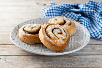 Cinnamon rolls buns. Kanelbulle Swedish dessert on wooden table