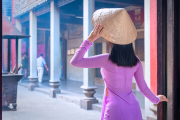 Vietnam woman wearing Ao Dai culture traditional at old temple at Ho Chi Minh in Vietnam,vintage style,travel and relaxing concept.