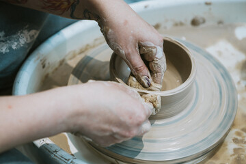 work in a pottery workshop. close-up of hands and potter's wheel