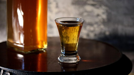 Whisky. Glass of whisky on wood background. Bottle of whisky on old wooden table.