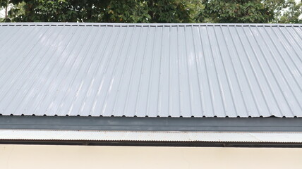 The gray metal sheet roof comprises the top floor of the building. © Phetmanee