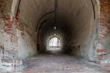 Tunnel through the fortification in the old town of Zamość. Barrel vault. Brick walkway. Zamosc, Poland