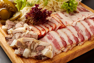Sliced bacon and meat terrine served with pickled vegetables.