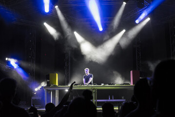 Dj playing techno music on the live night concert in summer