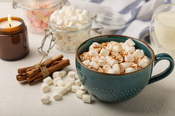 Cup of tasty cocoa drink and marshmallows in blue cup.Spices and marshmallows for winter drinks on white texture table.Winter hot drink.Hot chocolate with marshmallow and spices.Copy space.