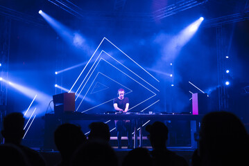 Dj playing techno music on the live night concert in summer