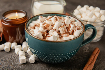Cup of tasty cocoa drink and marshmallows in blue cup.Spices and marshmallows for winter drinks on black texture table.Winter hot drink.Hot chocolate with marshmallow and spices.Copy space.