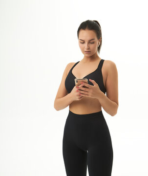 fitness girl on training in sportswear holds a smart phone in her hands