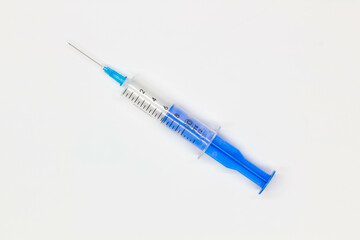 Blue medical disposable syringe for injection on a white background. Medical instrument for...