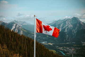 Canadian Flag overlooking mountains in Banff © Capturedbykeeleigh