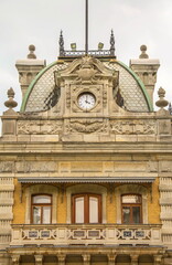Fragment of an old Gothic medieval building with a tower and a clock