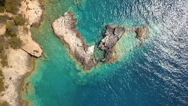 Italy, July 2022: Aerial view in 4K of the Tremiti islands in Puglia with n Caribbean sea, cliffs and boats off the coast
