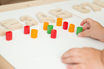 Math with fun. Calculation and marking of uncooked pasta with colored natural wood numbers. Do-it-yourself game. Play at home. The way of learning. Early education, counting game, fine motor skills.