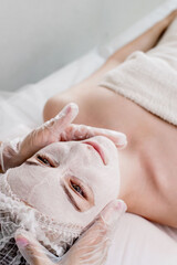 Obraz na płótnie Canvas Woman in moisturizing anti-wrinkle mask. A woman is lying down, resting in a beauty salon. SPA procedures at home or in a cosmetology center
