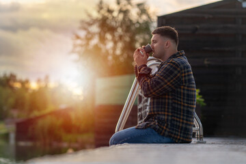 Thirsty young man drinking a cup of takeaway coffee