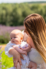 Young mother with her newborn baby outdoors at sunset