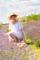 Mature woman kneeling down in a field of lavender