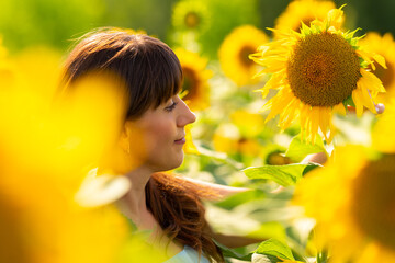 Attractuve brunette woman walking through a field of sunflowers