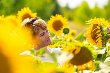 Face of an attractive blond woman surrounded by sunflowers