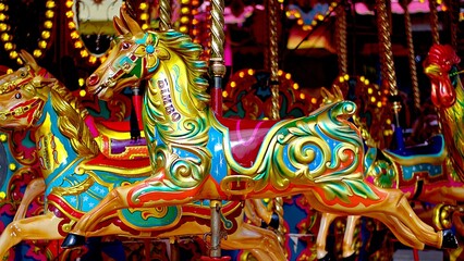 Fototapeta na wymiar Carousel ride merry-go-round wooden horses.