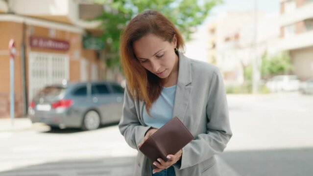 Young woman executive holding empty wallet at street