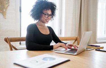 The receptionist is a woman with glasses who works in the office making a report with documents in the finance company