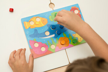 Match the color. Wooden table game with colored cylinders. Toy for Toddlers. For verbal and visual...