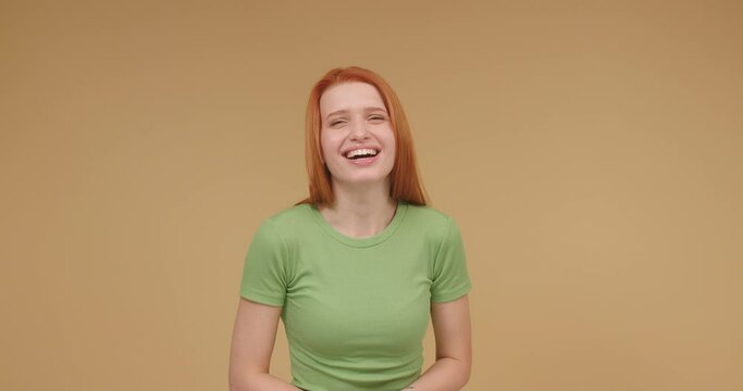 Young red-haired woman smiles and laughs enjoying life