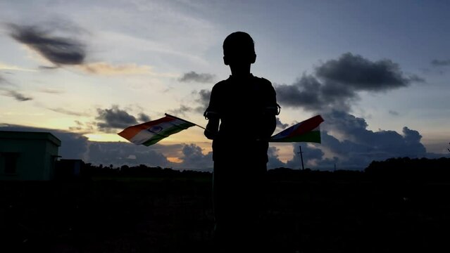
little Boy holding tri colour national Indian flag in the nature & waving flag in the air. Independence Day - Holiday and Republic Day