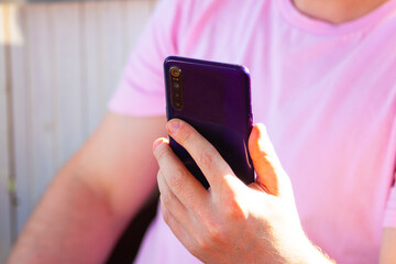 Fototapeta premium A man in pink watches technology news in nature