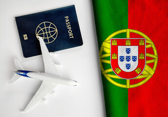 Flag of Portugal with passport and toy airplane. Flight travel concept
