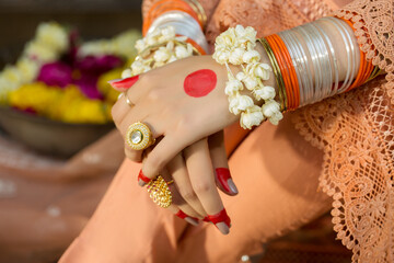 Women hands with bangles, rings and flowers