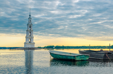Kalyazin, Russia. The bell tower of St. Nicholas Cathedral, known as the flooded bell tower, in the early morning against the background of fishing boats.