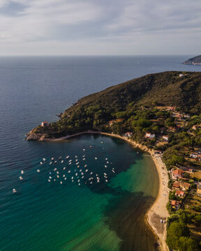 Aerial view of a small bay in Procchio along the coast with sailing boats docked, Elba Island, Italy.
