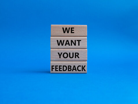 We want your feedback symbol. Wooden blocks with words We want your feedback. Beautiful blue background. We want your feedback concept. Copy space.